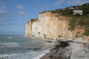 Vue panoramique de la plage de Saint-Pierre-en-Port, montrant les falaises imposantes et le littoral pittoresque de la Normandie.